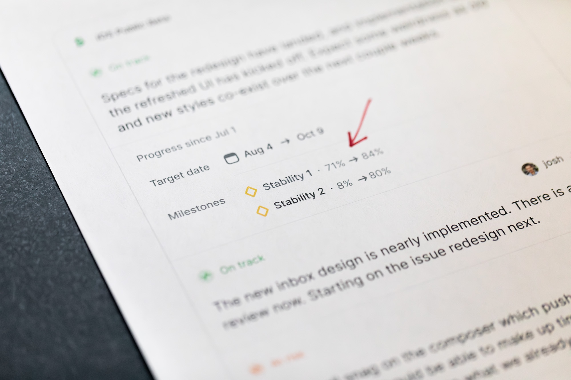 Progress report from a Linear project, highlighting what percent of milestones were completed since the last update. The progress report is printed out on a piece of paper, like it would be for an old school critique of the design.